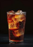 Refreshing glass of cola with ice on a dark background photo