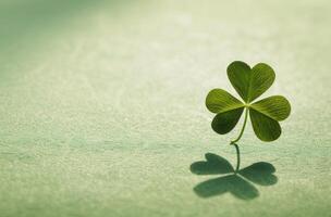 Four leaf clover casting a shadow on a textured surface photo