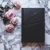 Elegant black notebook with pink roses on a marble background photo