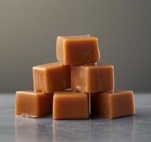 Stack of caramel candies on a reflective surface photo