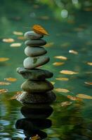 Zen stones in balance with autumn leaf on top photo