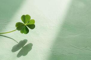 Four leaf clover casting a shadow on a textured surface photo