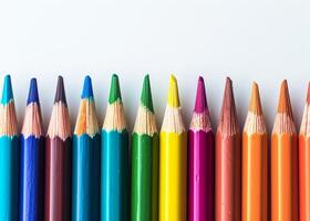 Colorful array of sharpened pencils lined up against a white background photo