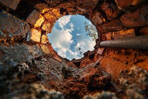 View through a broken brick wall to the sky photo