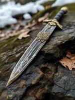 Medieval dagger on a rocky surface photo