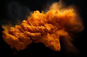 Explosive orange powder burst against a black background photo
