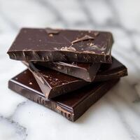 Stack of Dark Chocolate Bars on a Marble Surface photo