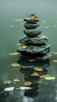 Zen stones in calm water with autumn leaves photo