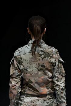 Rear view of a person in military uniform against a dark background photo