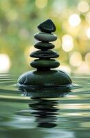 Zen stones in perfect balance on tranquil water photo