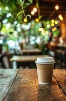 Disposable coffee cup on a rustic wooden table with a cozy cafe background photo
