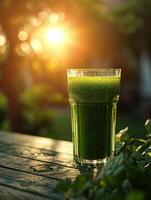 Fresh green juice on a wooden table with sunlight in the background photo