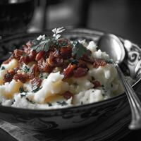 Delicious mashed potatoes topped with crispy bacon and fresh herbs photo