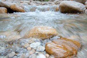 flowing stream with rocks and pebbles photo