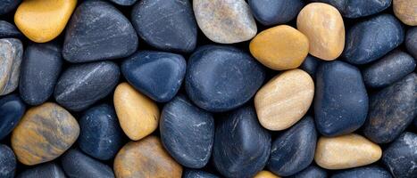 Smooth river rocks in various shades of gray and yellow photo