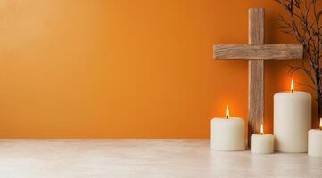 wooden cross and burning candles on orange background photo