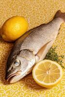 Fresh fish and lemon on patterned background photo