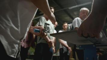 Woodworking master class. Creative. Close-up of man shows group of people how to take measurements on wooden board. Master class in carpentry in industrial workshop video
