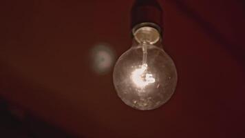 Switching on, turning off light bulb on white wall background. Footage. Blinking light over dark background. video