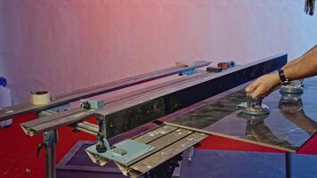 Manufacturing and processing of granite slabs. Creative. Worker using vacuum suction cups for carrying a lare tile. video