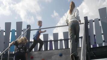 Children Engaged in Fun and Active Play on a Vibrantly Colorful Playground Climbing Structure. Action video