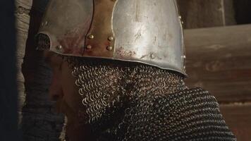 Medieval old knight helmet and chain mail for protection in battle. Media. Close up side view of a man in very heavy headdress, middle ages armor concept. video