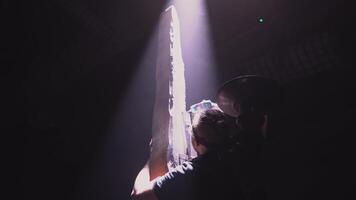 Low angle view of a worker assembling street lamp of a wooden beam and lamp. Media. Screwing lamp into wooden pillar. video