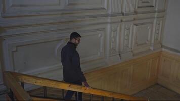 Man walks up old staircase of building. Media. Man walks up stairs alone in cultural building. Man walks up stairs of theater or old university video