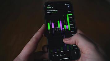 Financial chart on phone. Media. Close-up of man viewing cryptocurrency on phone diagram. Cryptocurrency and Stock Exchange Lines video