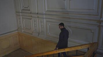 Man walks up old staircase of building. Media. Man walks up stairs alone in cultural building. Man walks up stairs of theater or old university video