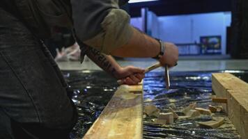 Close up of worker using tools for making holes in wooden beam. Media. Carpentry works for making decorations. video