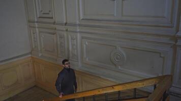 Man walks up old staircase of building. Media. Man walks up stairs alone in cultural building. Man walks up stairs of theater or old university video