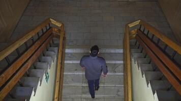 Top view of man walking up stairs of old building. Media. Young man climbs stairs in old university building. Man walks up stairs in theater or university college building video