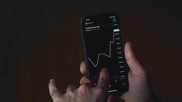 Crypto currency trading chart mobile phone. Media. Close-up of man looking at currency chart on his phone. Cryptocurrency chart on stock exchange from your phone video