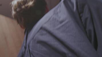 Rear view of a drunk young man trying to get out of room of a hotel and falling down. Stock clip. Concept of alcoholism. video