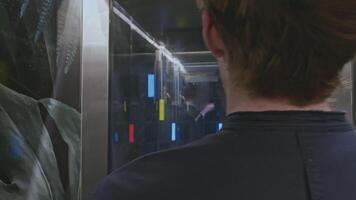 Close up of people inside elevator. Stock clip. People leaving glass walls elevator. video