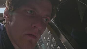 Close up of man listening carefully to the noise of elevator malfunction and pressing the floor button. Stock clip. Men risking to use the faulty elevator. video