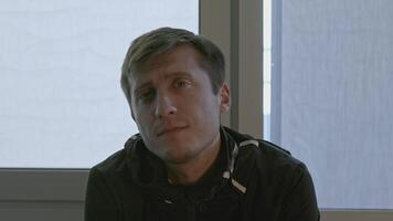 Close-up of man with an interested expression looks at camera. Stock. Man tilts head with interest and looks at camera. Interesting facial expressions of man looking at camera video