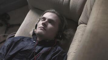 Young man is lying on couch and trying to fall asleep. Stock. Young man with anxiety is trying to fall asleep. Young man is lying on couch and restlessly trying to fall asleep video