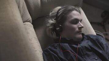 Young man is lying on couch and trying to fall asleep. Stock. Young man with anxiety is trying to fall asleep. Young man is lying on couch and restlessly trying to fall asleep video