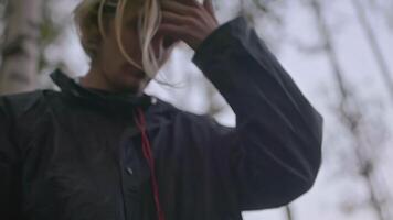 Close-up of man holding straw in forest. Stock. Young man walks in forest and tears up grass. Man picked grass out of boredom while walking in forest video
