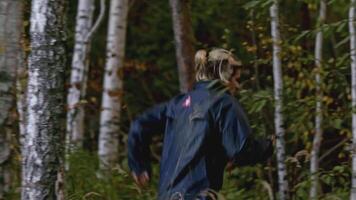 Man walks in woods with phone. Stock. Young man is walking along coordinates in phone in forest. Man is looking for way out of forest by phone video