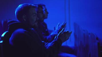 Men applaud performance in theater. Media. Men sit in one row and clap for performance. Theatrical performance with dark hall and applauding audience video