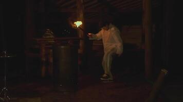 Man with torch in forest at night. Clip. Creepy man with burning torch in dark forest. Ritual torch in hands of frightening man in forest video