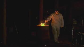 Man with torch in forest at night. Clip. Creepy man with burning torch in dark forest. Ritual torch in hands of frightening man in forest video
