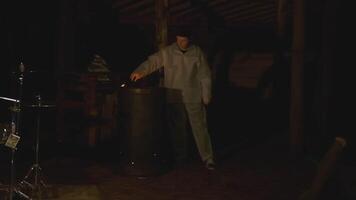Man with torch in forest at night. Clip. Creepy man with burning torch in dark forest. Ritual torch in hands of frightening man in forest video