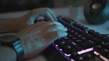 Close-up of male hands typing on glowing keyboard. Clip. Man is typing on professional backlit keyboard. Stylish backlit keyboard for working or playing on computer video