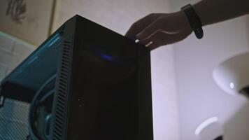 Computer with backlight. Clip. Man turns on computer with backlight inside. Beautiful stylish computer processor design with backlight for gaming and work video