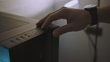 Close-up of man pressing computer start button. Clip. Man turns on modern computer. Gaming professional PC with beautiful design video