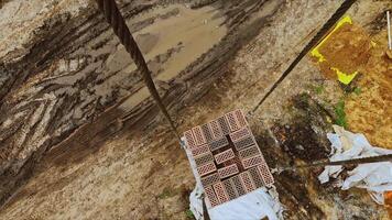 Timelapse of moving bricks from crane. Clip. Workers load bricks onto construction crane for transfer. Camera on crane for carrying heavy bricks on construction site video